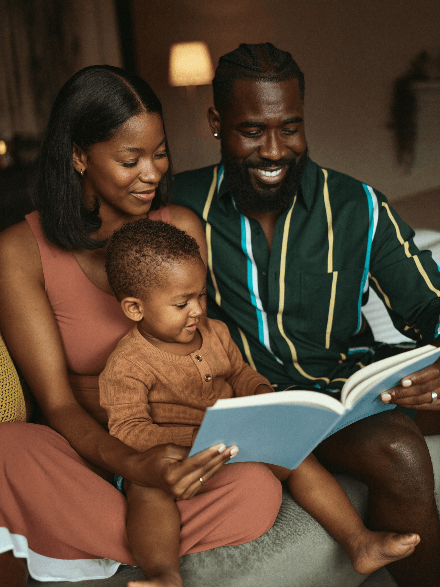 Família lendo um livro junta, à noite, em casa